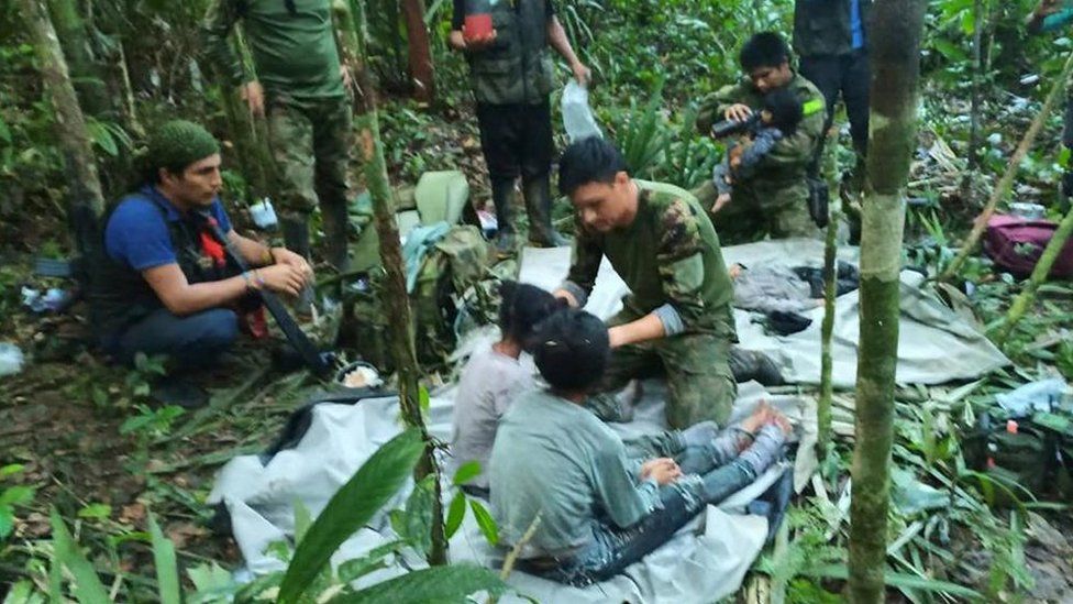Спасатели оказывают помощь детям в джунглях Какета после их обнаружения 9 июня