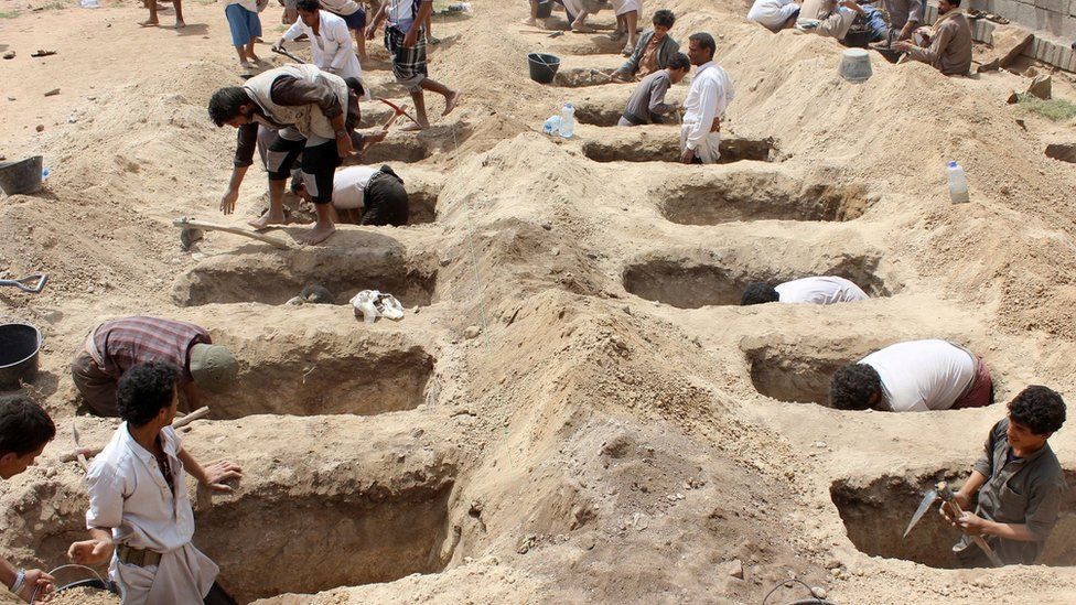 Yemenis dig graves for children in the wake of an air strike on a bus in Saada province