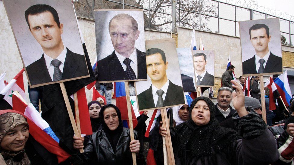 Syrian pro-government protesters hold up photographs of Bashar al-Assad and Vladimir Putin outside the Russian embassy in Damascus (4 March 2012)