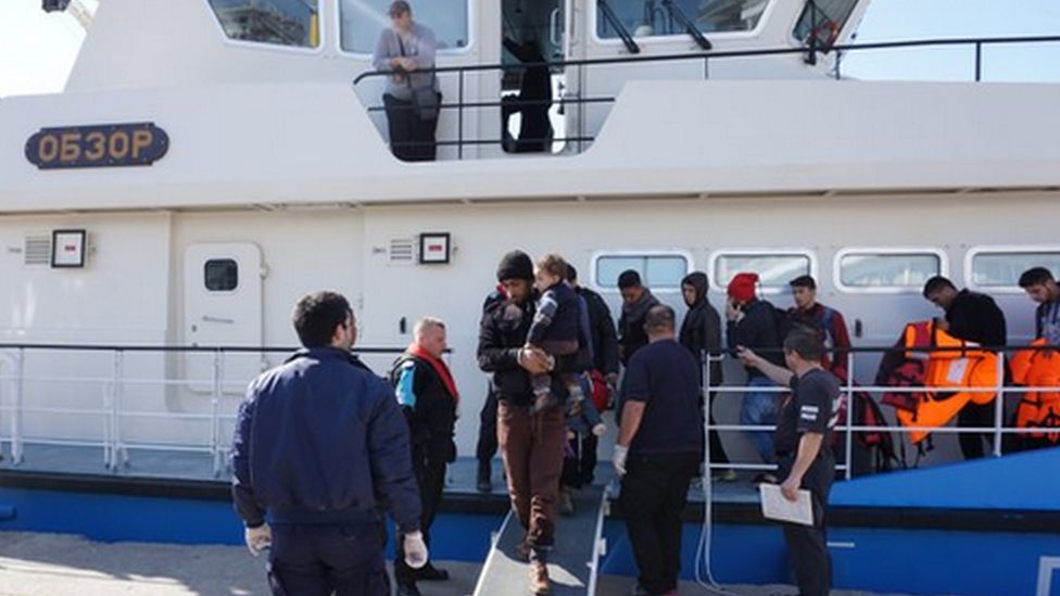 Migrants disembark a Bulgarian vessel