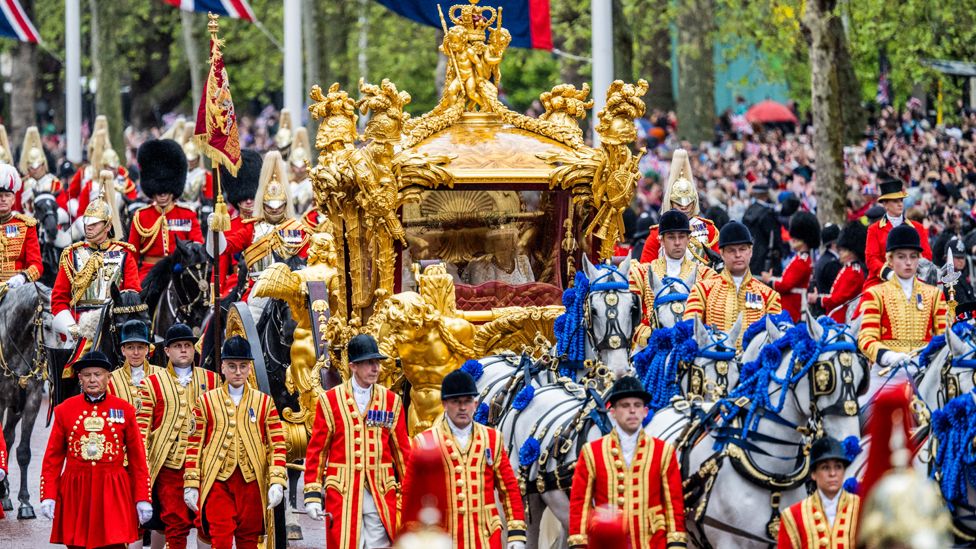The Gold State Coach carrying King Charles III and Queen Camilla heads down The Mall