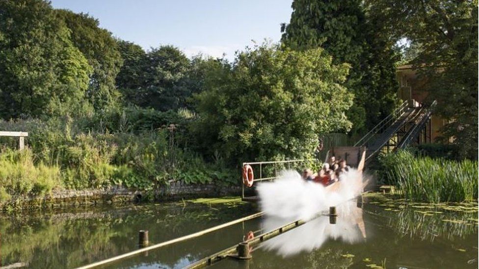 Water chute, with boat making a splash at the bottom as it glides across a lake