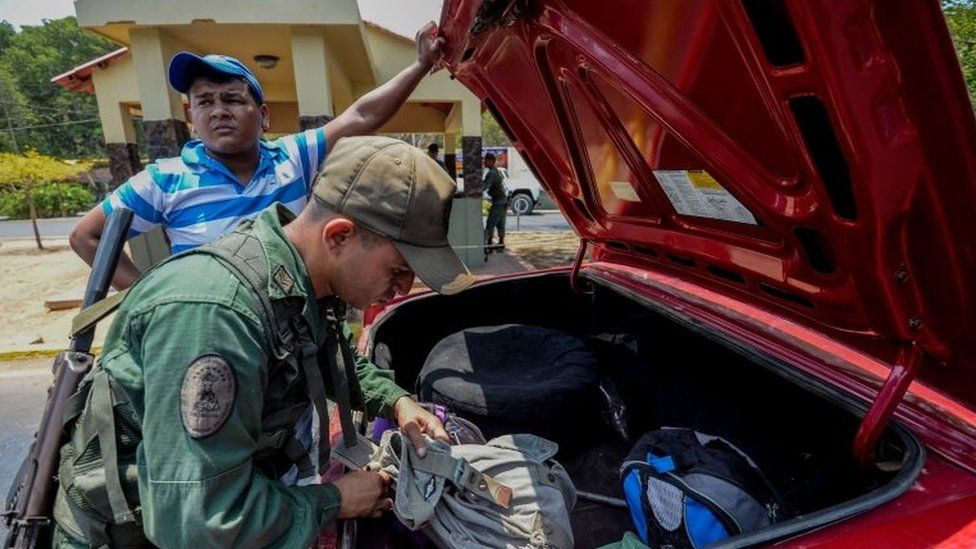 A Venezuelan officer checks a car at a checkpoint in Paraguachon, Zulia state, Venezuela, on September 14, 2015.