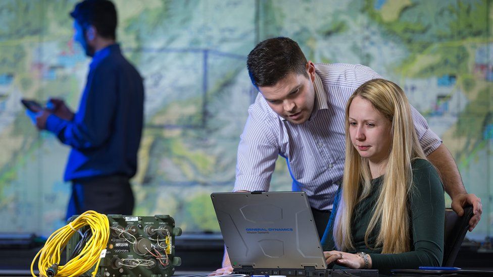 People working on communications equipment