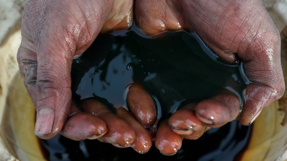 A Russian employee holds a sample of crude oil
