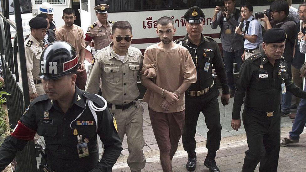 I sospettati stranieri dell'attentato al santuario di Erawan del 17 agosto, identificati dalla giunta al potere come Adem Karadag (C,R) e Yusufu Mieraili (C, di spalle a L), arrivano presso un tribunale militare a Bangkok il 16 febbraio 2016.