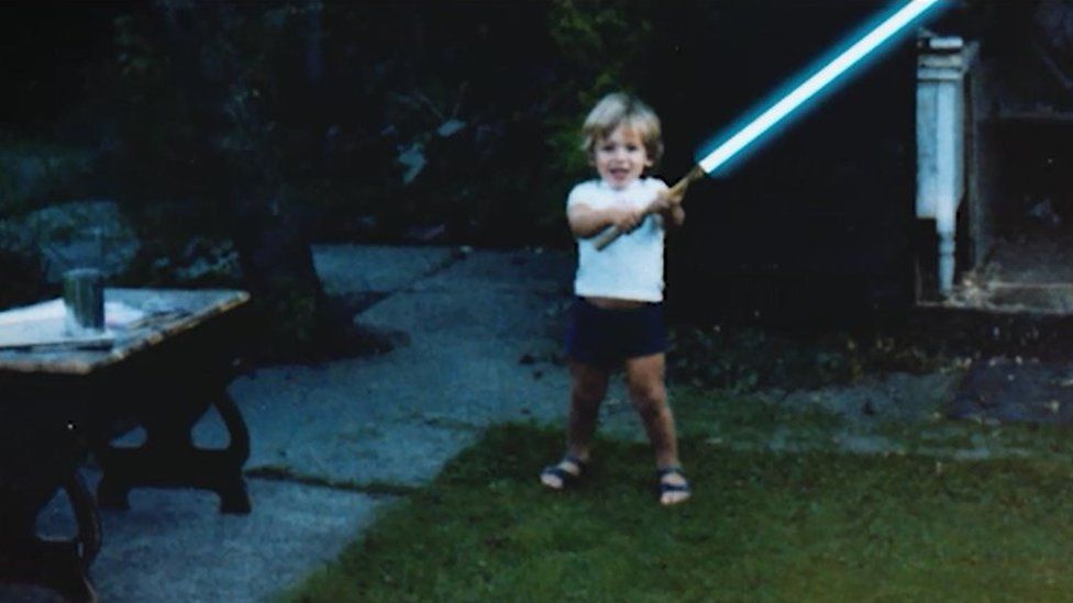 David Whiteley with 'lightsaber' in garden