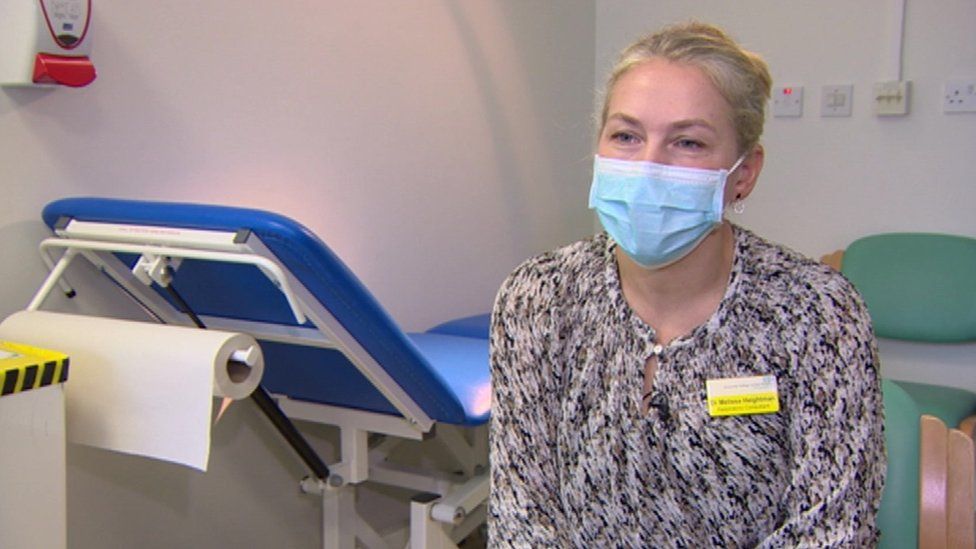 Dr Heightman in a treatment room surrounded by medical equipment.