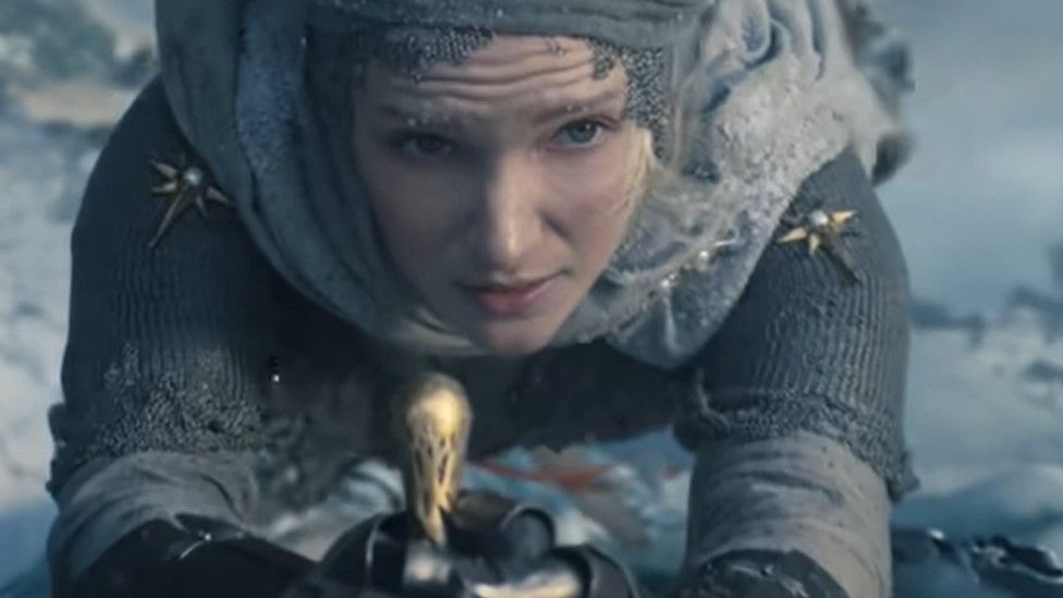 A young Galadriel, played by Morfydd Clark, is shown scaling up an icy cliff face in the new trailer