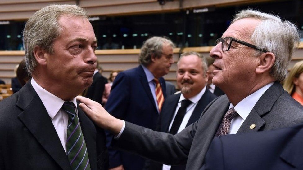 UK Independence Party (UKIP) leader Nigel Farage (L) talks with EU Commission President Jean-Claude Juncker