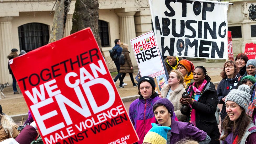 Women hold placards as they take part in Million Women Rise march through central London to New Scotland Yard in a protest demanding an end to male violence against women and children ahead of International Women's Day on 5 March 2022