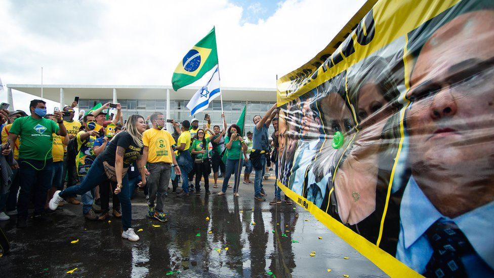 Supporters of Brazilian President Jair Bolsonaro throw water balloons during a protest against lockdown measures