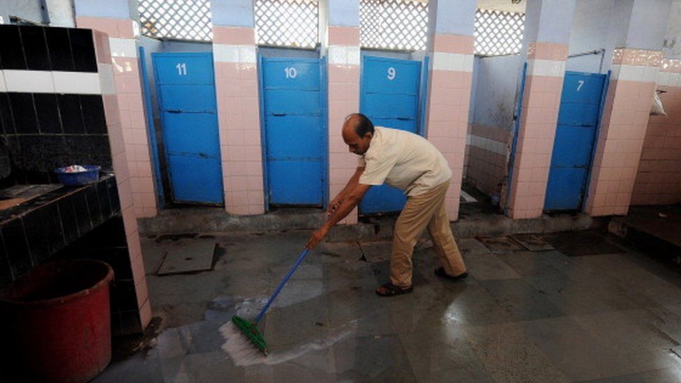 An Indian sweeper cleans a toilet complex run by an NGO Sulabh International at railway station in New Delhi on April 23, 2011.