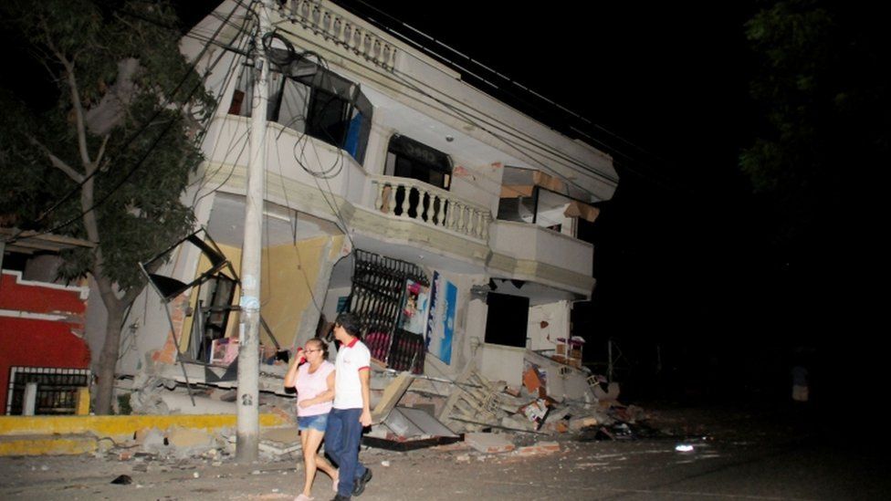 Residents walk on a street amid destroyed buildings following an earthquake, Guayaquil, Ecuador