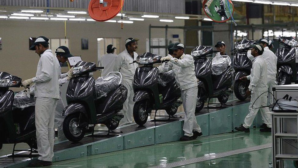 Indian skilled workers work on an assembly line for Honda Activa scooters at the new plant in Vithalapur, some 80 km from Ahmedabad on February 17, 2016. It is the fourth HSMI plant in India and the first scooter plant