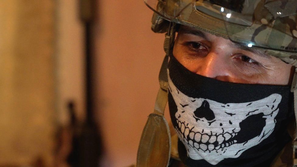 Sniping squad  commander, Ghost, is pictured wearing a subject   helmet with a disguise  featuring a skull plan  covering his rima  and nose