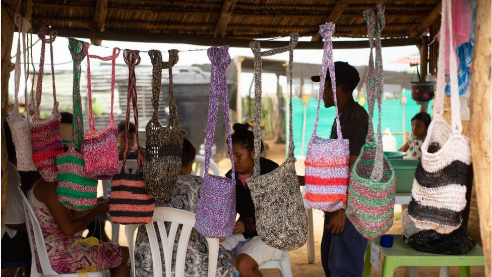 A Venezuelan migrant sells handbags in a Colombian refugee camp