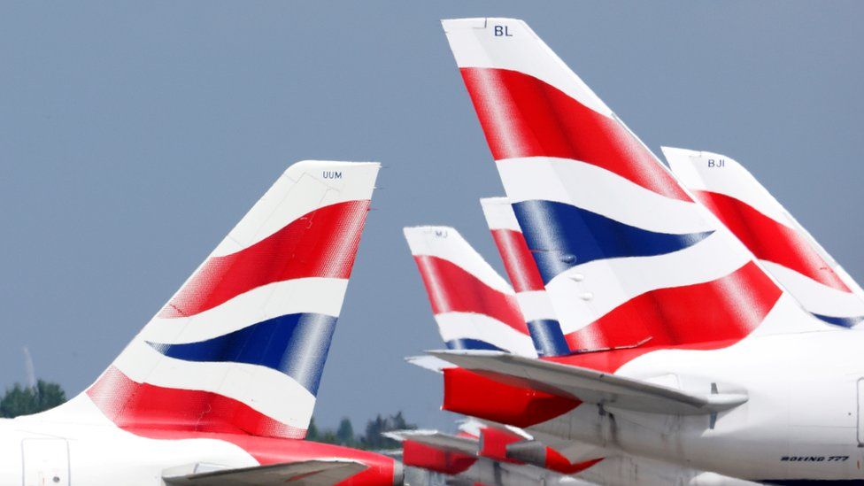 British Airways plane tail fins - which feature the UK flag - are arrayed in rows at an airport