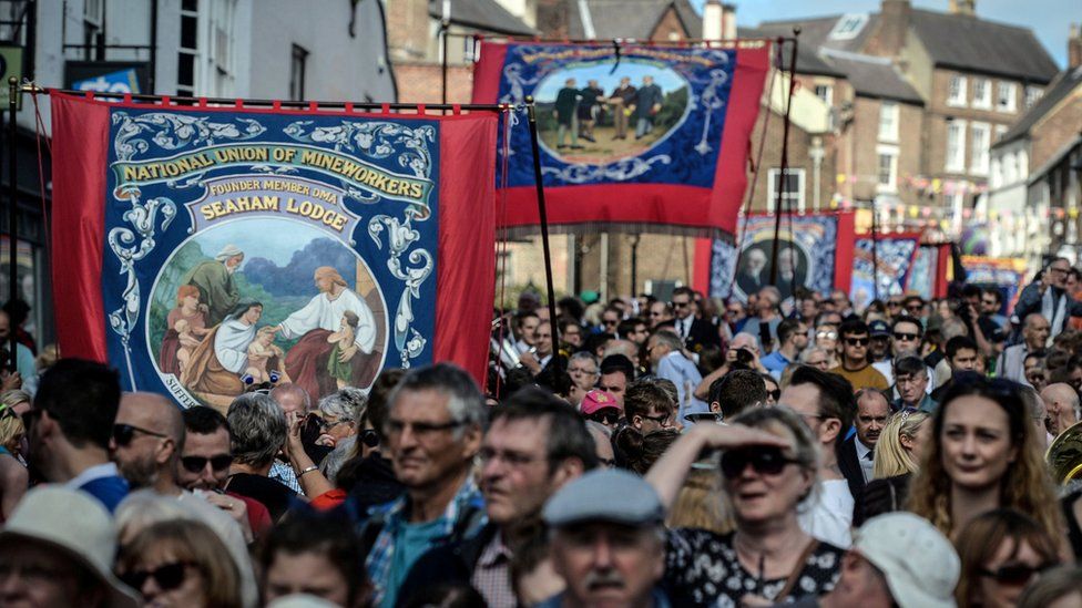 Crowds at a previous gala with many marchers holding colliery banners