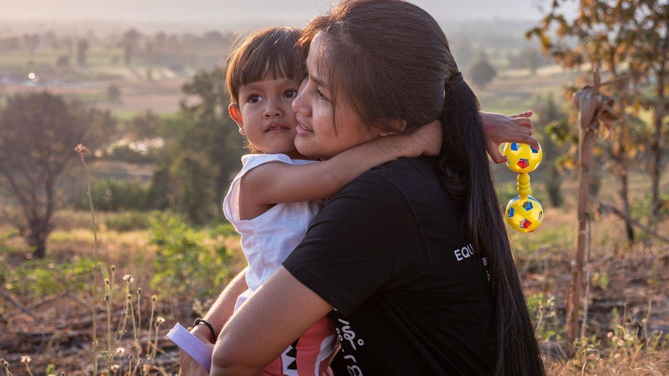 Гражданка Бирмы Моэ Сандар Мьинт обнимает одного из трех своих детей, которые живут с ней и ее мужем в Таиланде после мучительного побега из Мьянмы