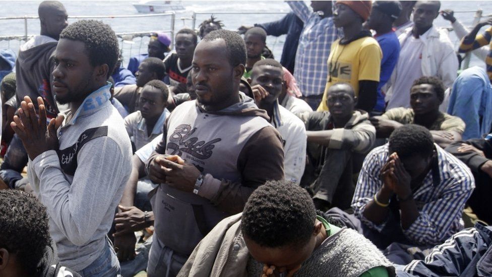 Migrants pray as they arrive aboard the Belgian Navy Vessel Godetia at the Trapani harbor, Sicily, Italy, Wednesday, 24 June 2015