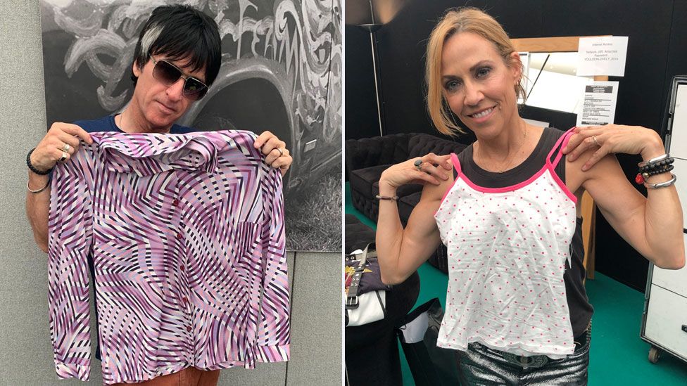Johnny Marr and Sheryl Crow hold up the clothes they donated