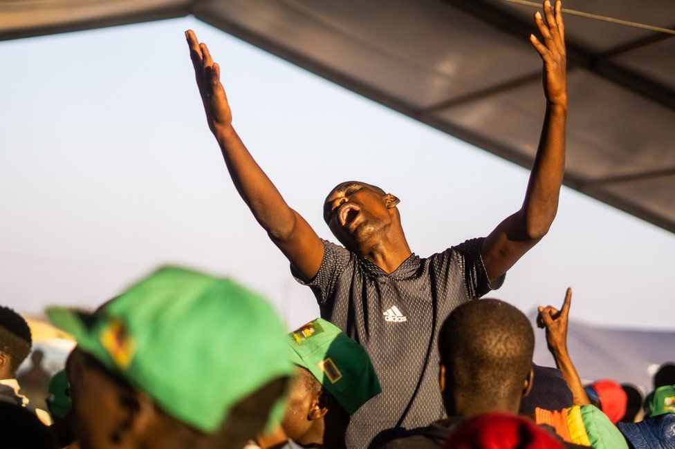 Mourners sing and dance in the early hours following a vigil for late former Zimbabwe President Robert Mugabe at the homestead in Kutama village on 17 September 2019