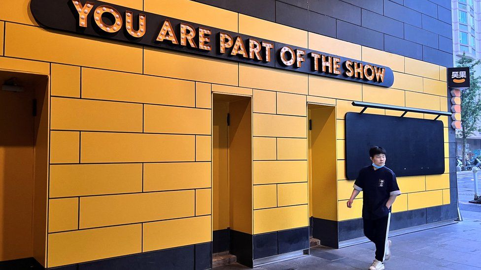 A person walks past a show venue of stand-up comedy company Xiaoguo Culture Media Co that has closed its business, in Beijing, China May 19, 2023. REUTERS/Tingshu Wang