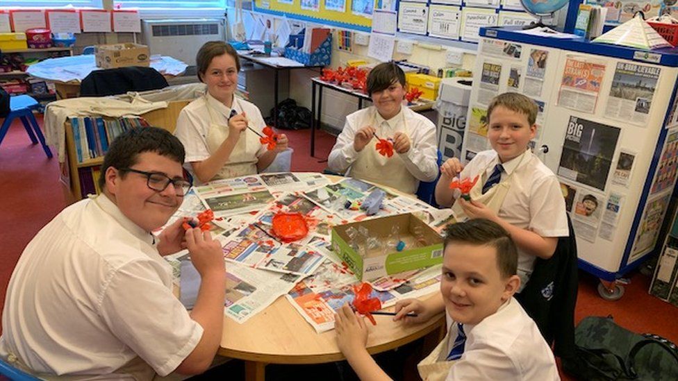 School children making poppies out of plastic bottles