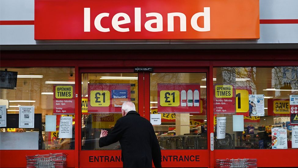 File image of a man reading a notice on an Iceland supermarket in Liverpool