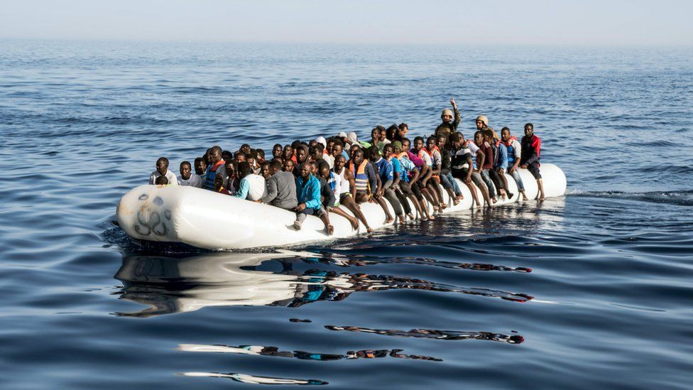 A picture taken on June 27, 2017 shows Libyan coast guardsmen standing in a dinghy carrying illegal immigrants during a rescue operation of 147 people who were attempting to reach Europe