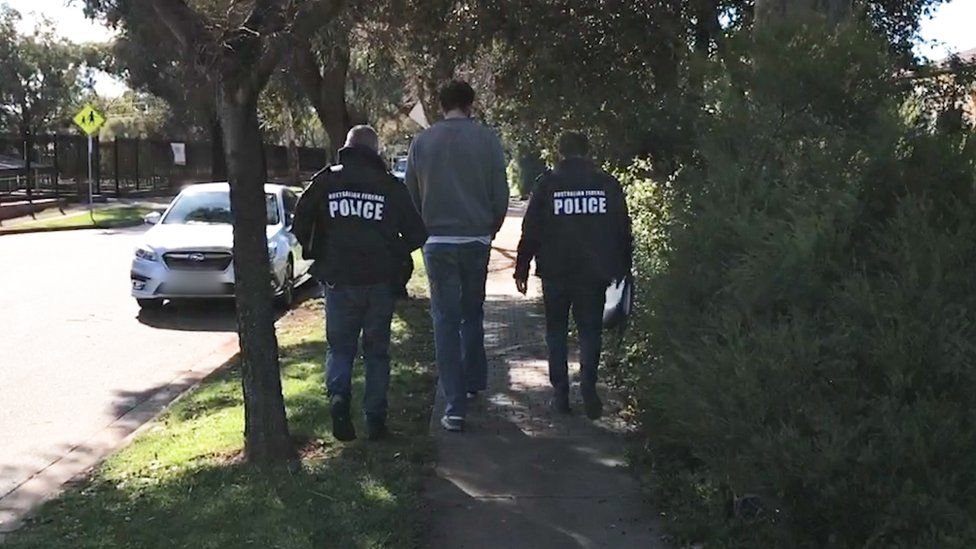Two police officers with a man in Adelaide
