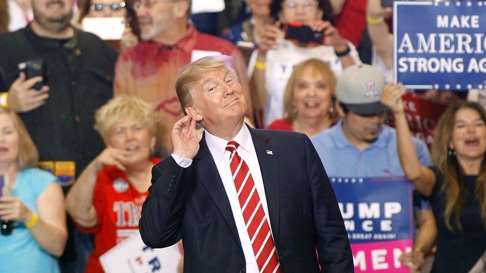 Donald Trump listens at a rally in Arizona.