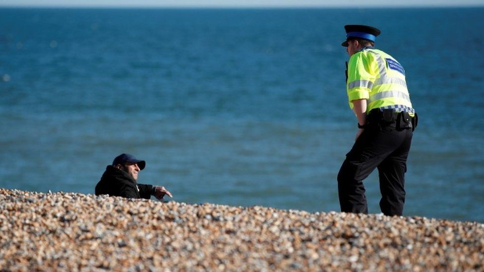 Police speaking to a man on Brighton beach