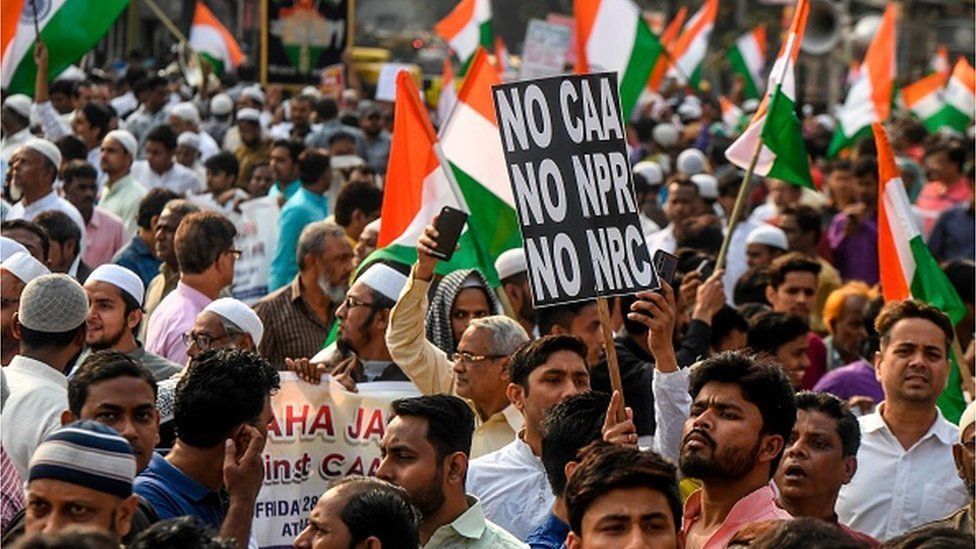Demonstrators hold Indian national flags and placards as they protest against India's new citizenship law during a demonstration in Kolkata on February 28, 2020. (Photo by Dibyangshu SARKAR / AFP)