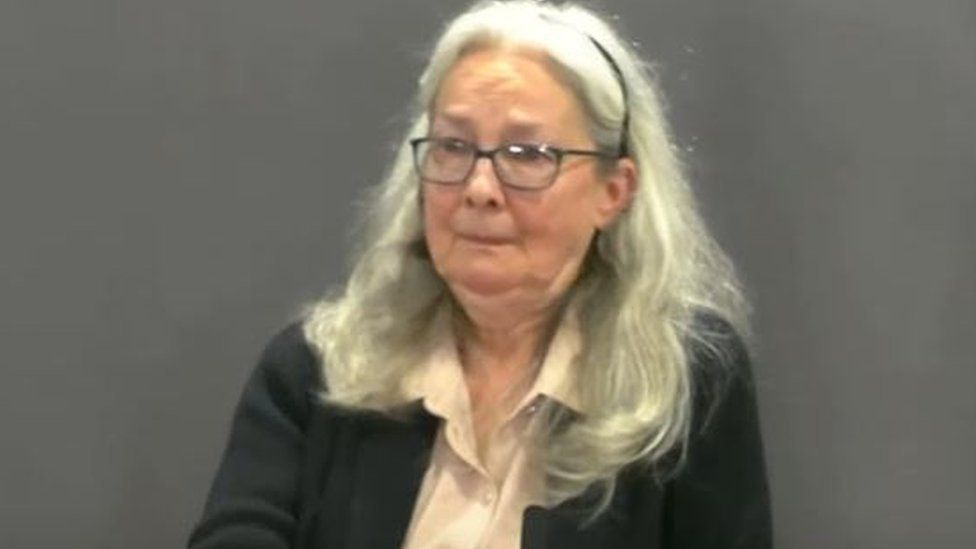 Jennifer O'Dell with shoulder-length light coloured hair wearing dark framed glasses and a dark cardigan over a light coloured shirt 