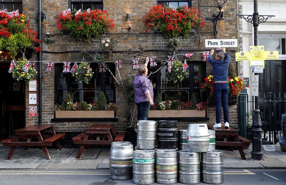 People decorate a pub with Union Flag bunting a day ahead of the royal wedding between Princess Eugenie and Jack Brooksbank in Windsor, Britain, October 11, 2018