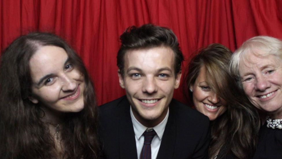 Megan, Louis Tomlinson, his mum Johanna and Jean pictured smiling in a photobooth-style setting at the charity's Cinderella Ball.