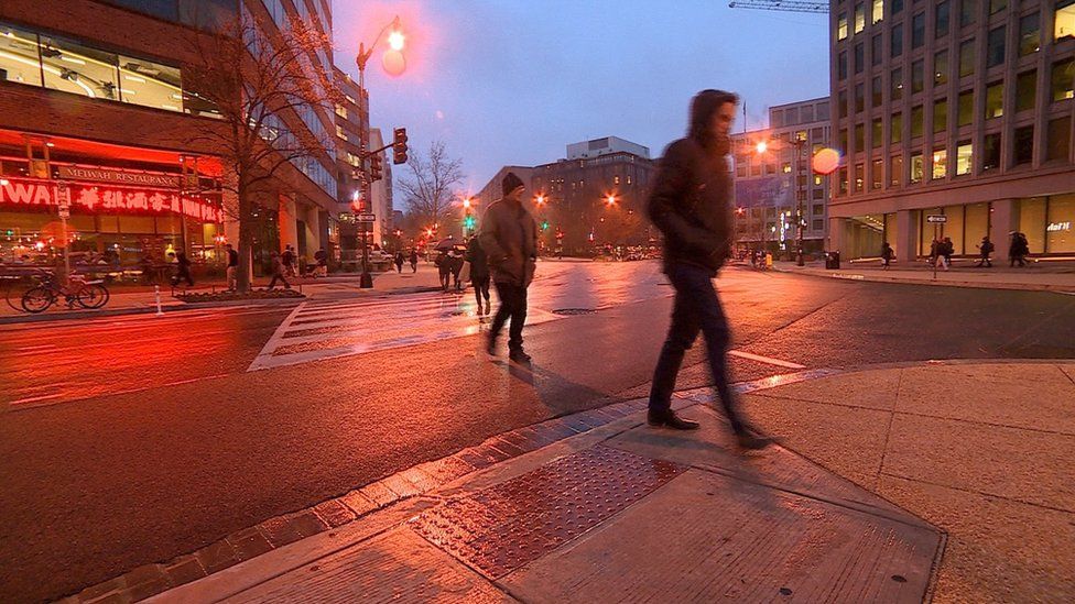 People walk across a street in Washington