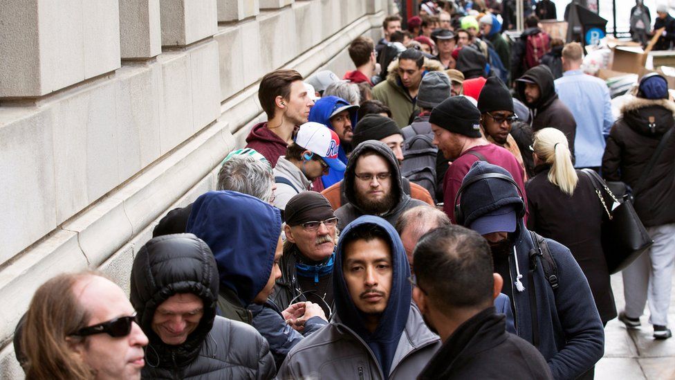 People wait in line for the opening of the Quebec Cannabis Society store