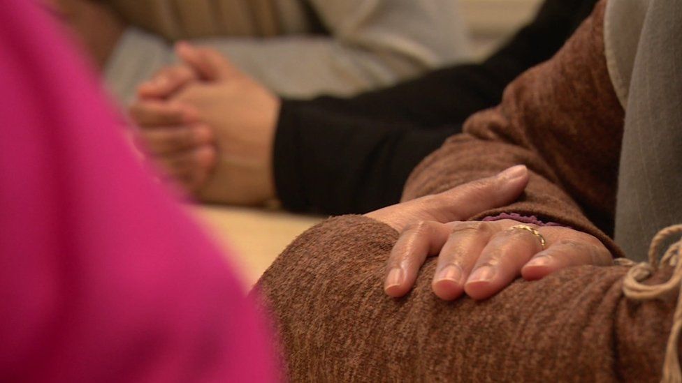 Image showing the arms and hands of anonymised women at a support group meeting