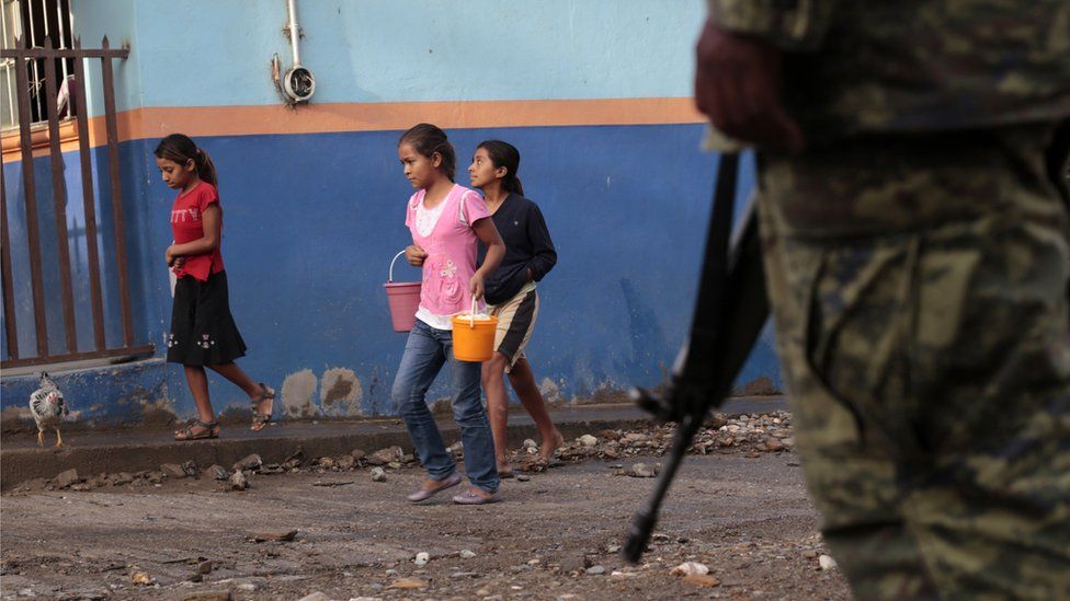 Girls are escorted by soldiers as they walks in Huatla village, Heliodoro Castillo municipality, Guerrero State, Mexico, on 3 August, 2013