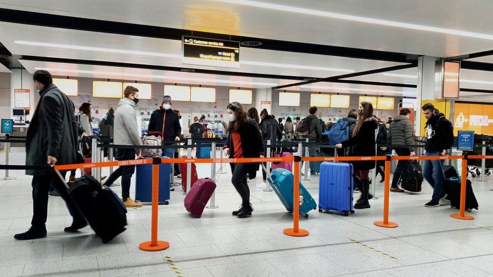 Passengers queue for check-in at Gatwick Airport in West Sussex.