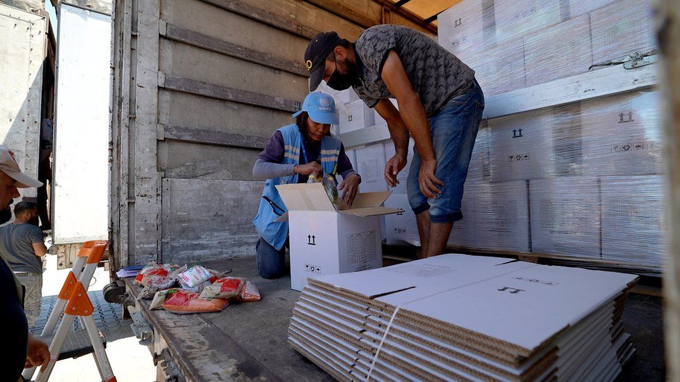 UN staff check the content of the aid lorries before they cross into Syria