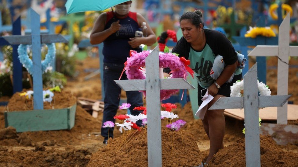 People attend a collective burial of people that have passed away due to the coronavirus disease