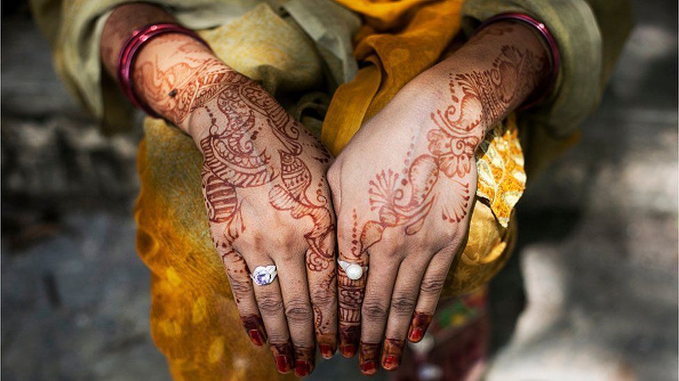 An Indian woman with hennaed hands