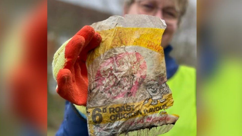 Woman holding an old crisp packet
