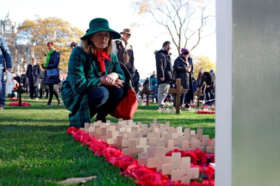 A woman looks at Remembrance Crosses during the short service of Remembrance