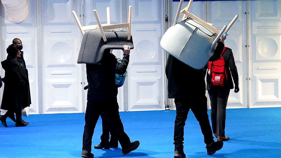 workmen carry COP26 chairs