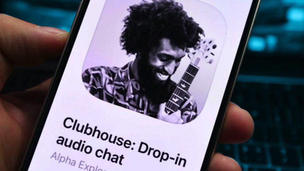 A person holding an iPhone with the Clubhouse app open